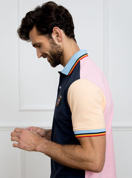 Man wearing navy based multicoloured panelled 100% cotton polo shirt with giant number 8 on pale pink back.